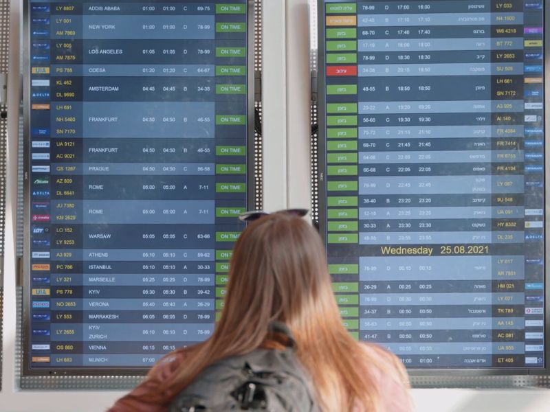 devojka gleda letove na ekranu na aerodromu