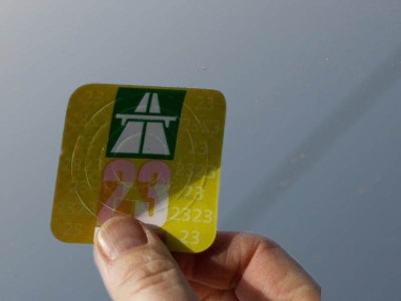 osoba lepi vinjetu na šoferšajbnu